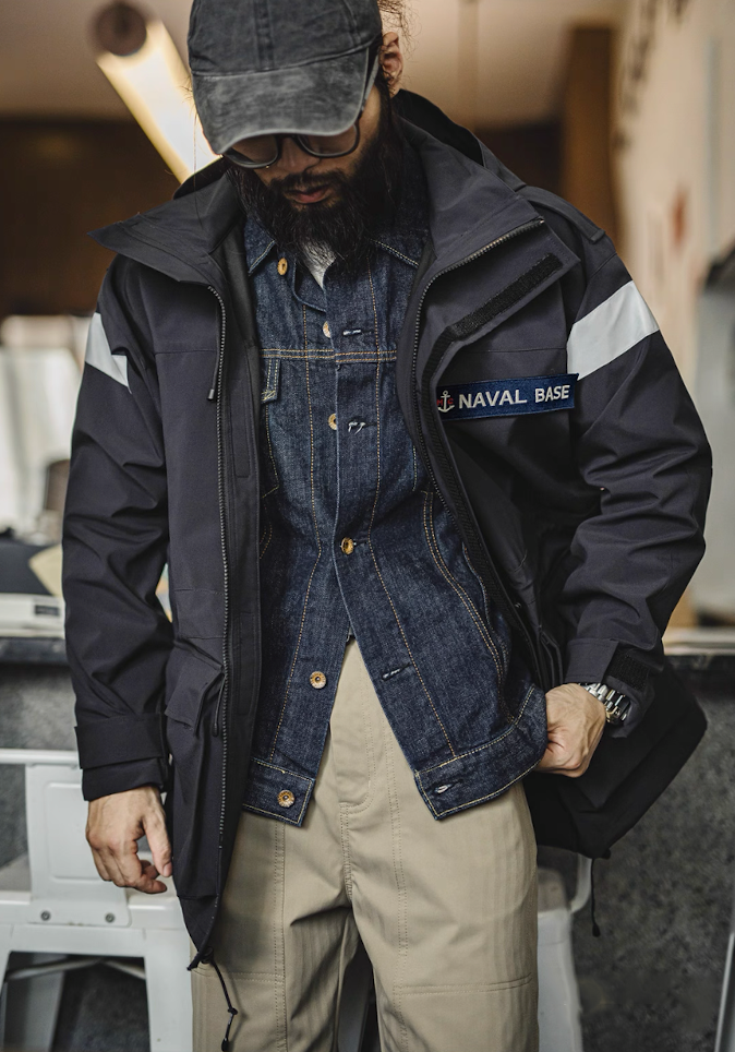 Model wearing “Naval Base” parka layered over denim jacket for rugged streetwear look
