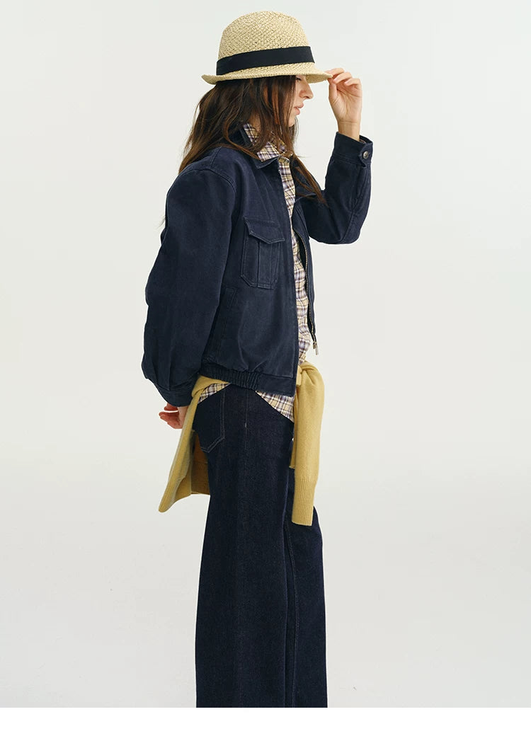 Side profile of a navy cropped utility jacket with flap chest pocket and elastic hem