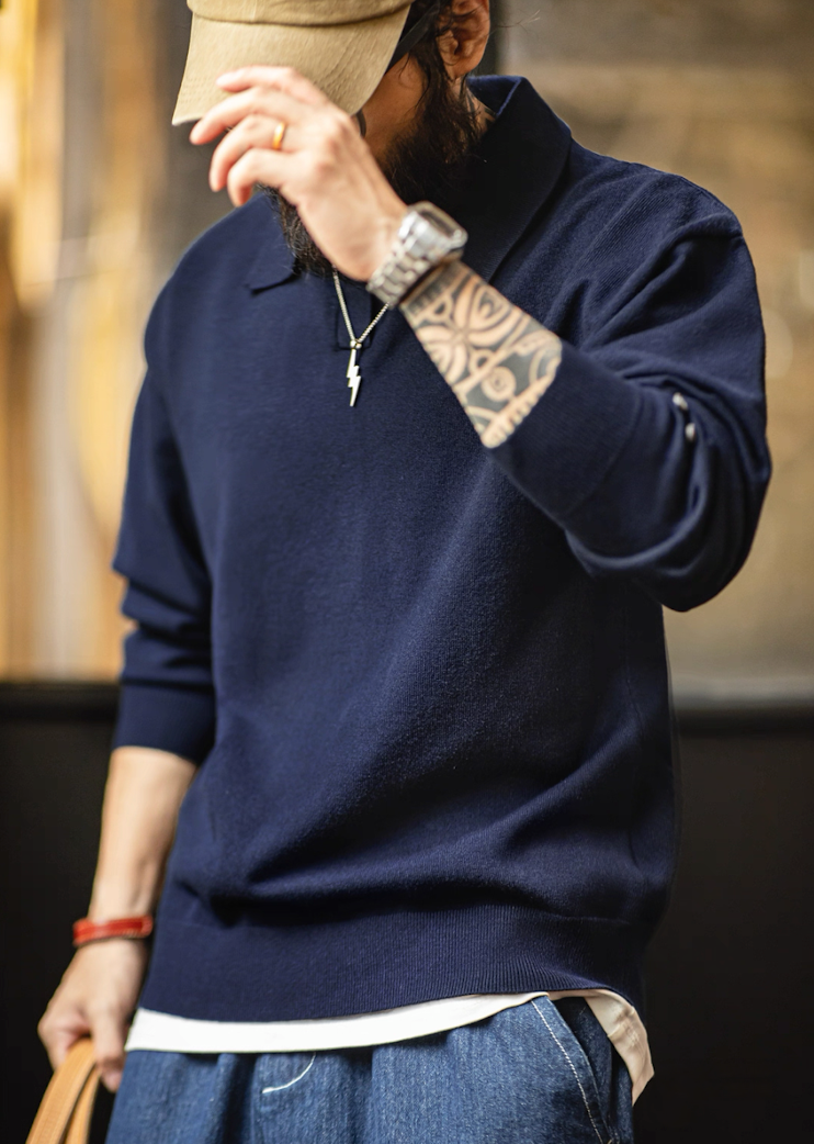 Lifestyle shot of model wearing navy blue knit polo sweater with natural movement.