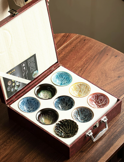 Nine-Piece Kiln-Glazed Artisan Tea Cup Collection displayed in open gift box showing nine-color ceramic tea cups arranged in protective case