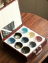 Nine-Piece Kiln-Glazed Artisan Tea Cup Collection displayed in open gift box showing nine-color ceramic tea cups arranged in protective case