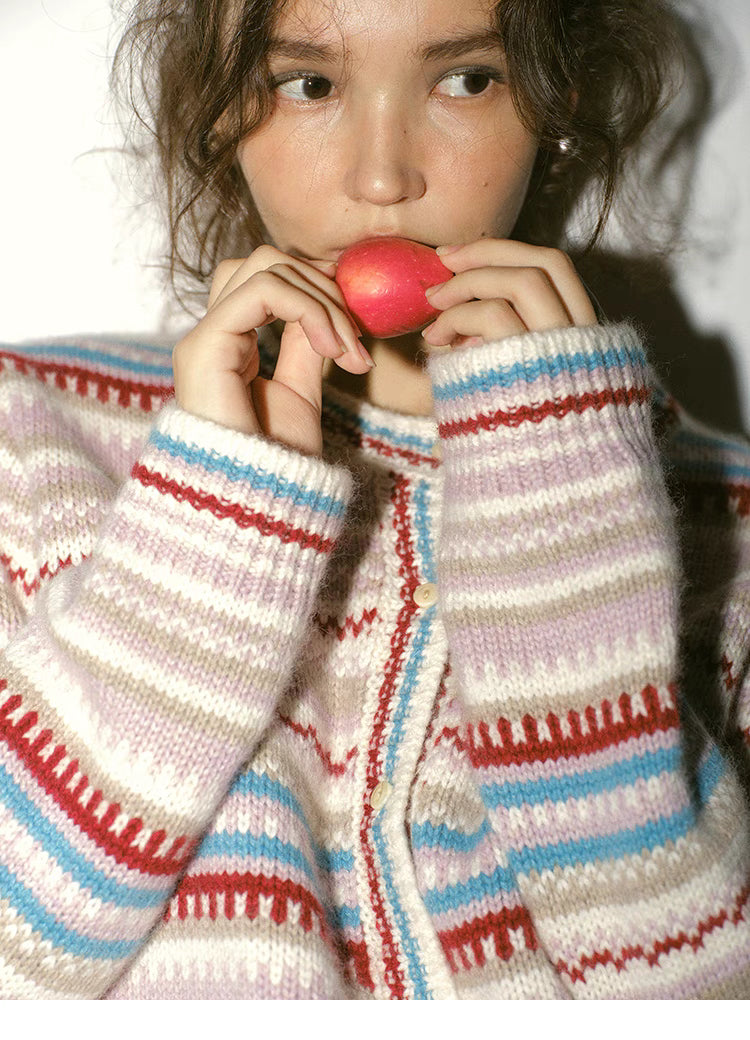 Close up of beige fair isle cardigan with red and blue stripes highlighting soft wool blend texture and cuffs