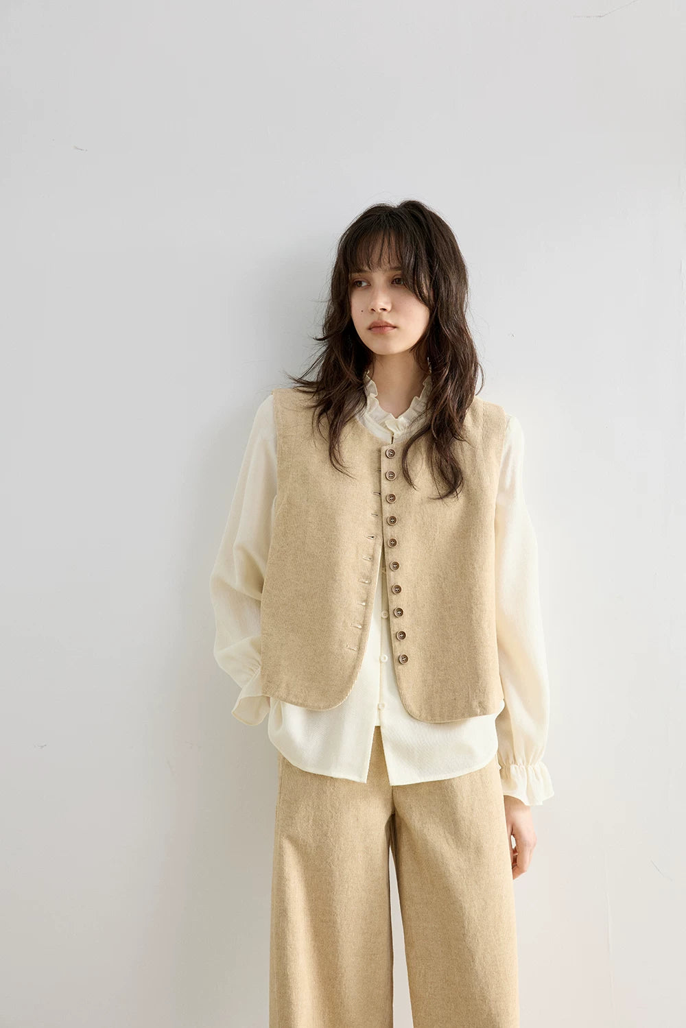 Front view of Oatmeal cropped corduroy vest with round collarless neckline and button row