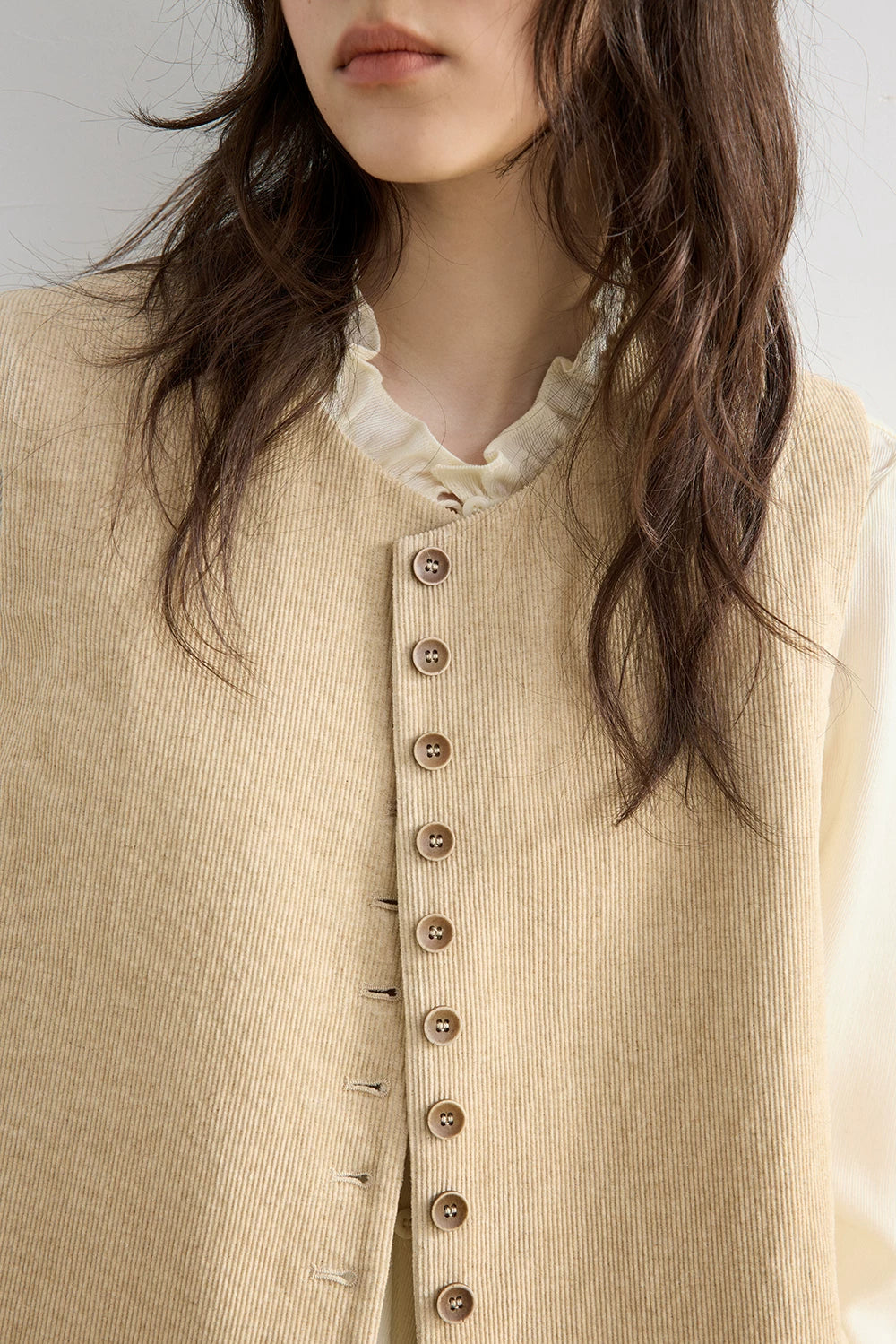Close-up of Oatmeal cotton-linen corduroy texture and vintage round buttons on vest