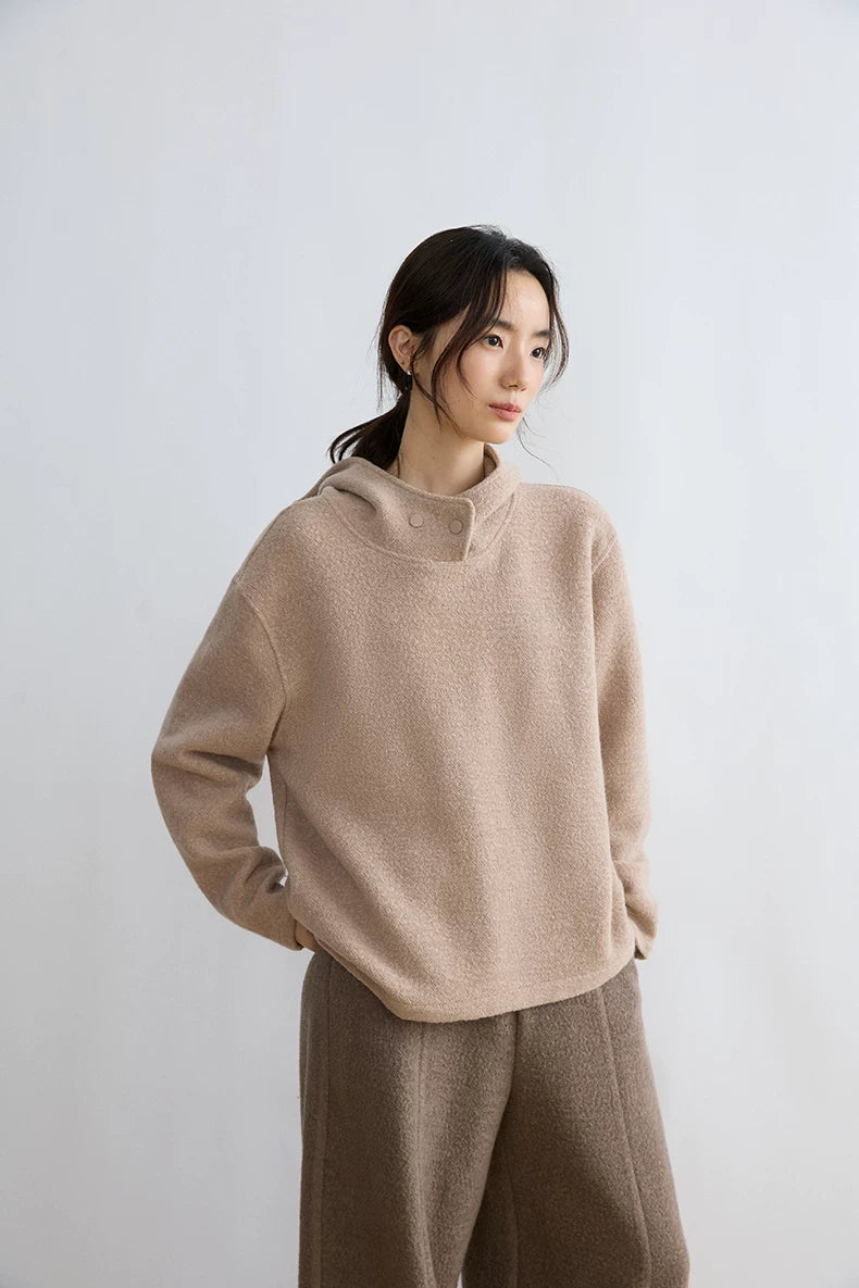 Woman wearing Oatmeal loop-textured hoodie with dropped shoulders and taupe wide-leg trousers