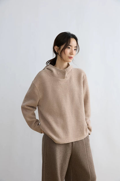 Woman wearing Oatmeal loop-textured hoodie with dropped shoulders and taupe wide-leg trousers
