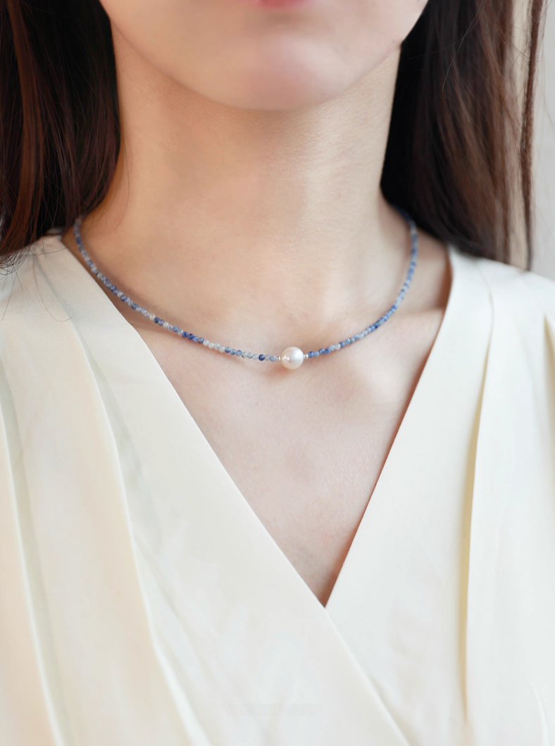 Ocean Whisper Pearl Necklace worn on neck featuring delicate blue sodalite beads and single freshwater pearl centerpiece