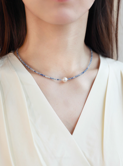 Ocean Whisper Pearl Necklace worn on neck featuring delicate blue sodalite beads and single freshwater pearl centerpiece