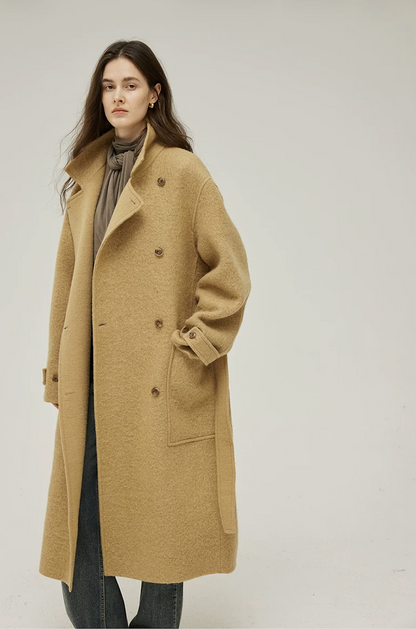 Ochre wool coat worn open with the lapels turned up and a hand in the low patch pocket