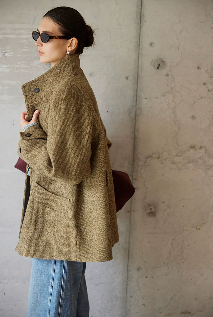 Side view of an Olive wool tweed jacket showing the tall stand collar and patch pocket