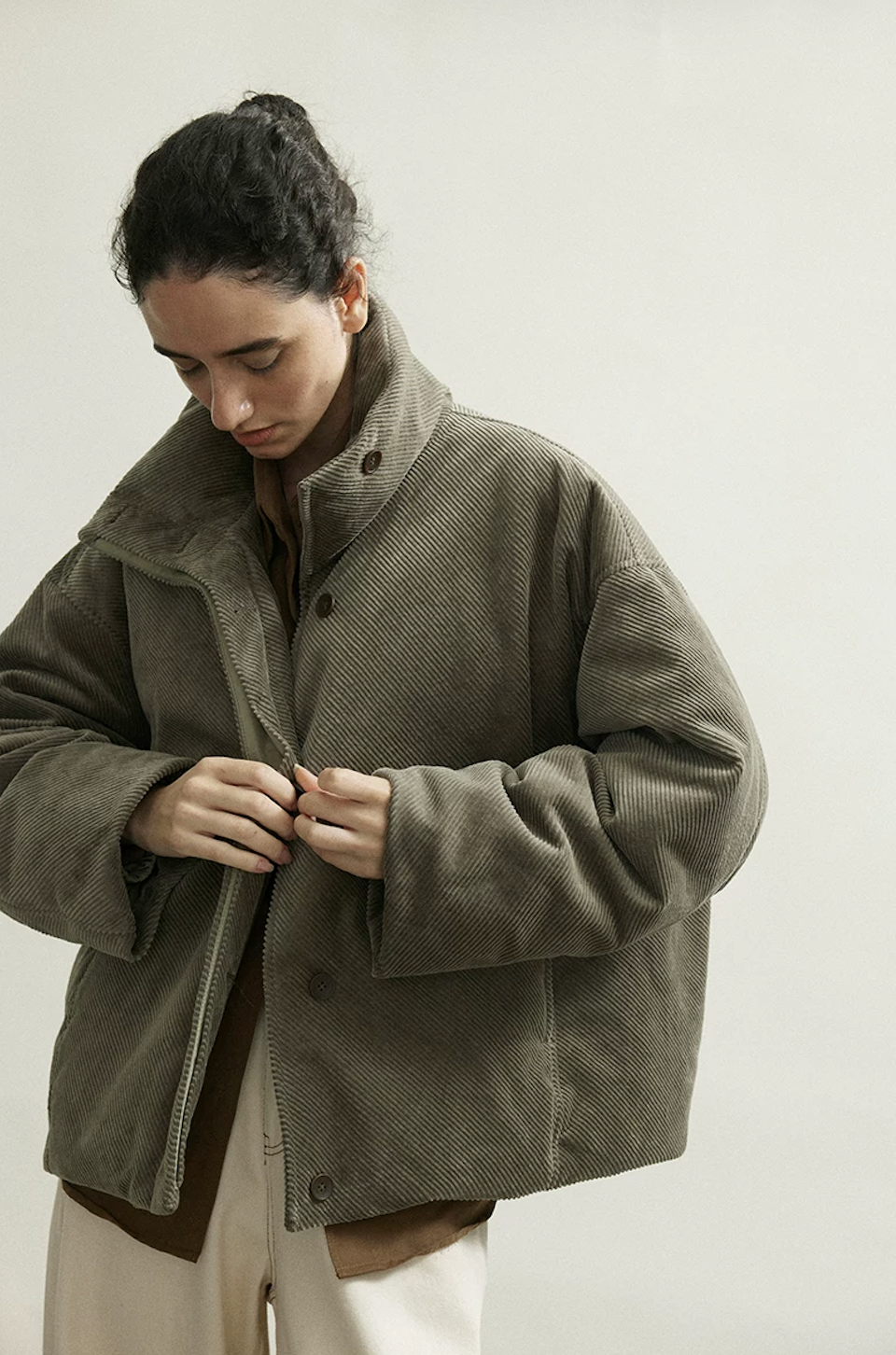 Olive Gray corduroy down jacket showing the inner zip and outer button placket