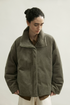 Front view of an Olive Gray boxy corduroy down jacket closed with a concealed placket