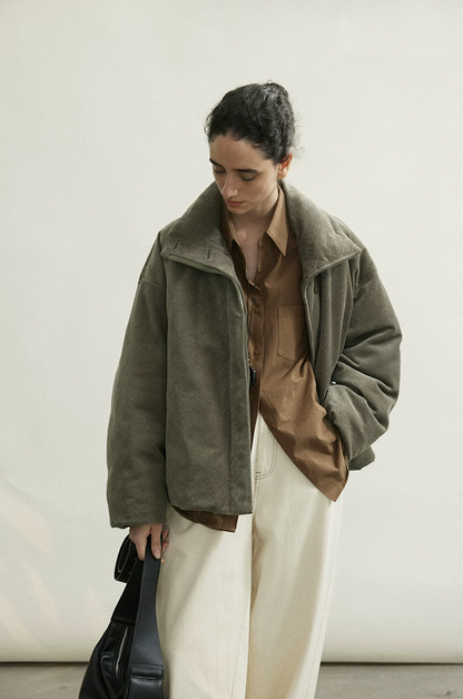 Olive Gray oversized corduroy down jacket worn open, with tall folded collar and side pocket