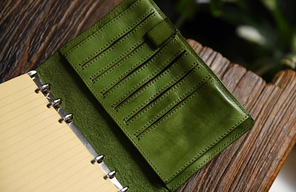Open olive leather journal showing multiple card slots and stitched interior.