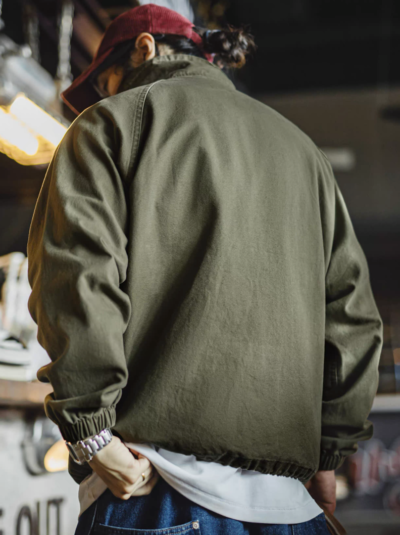 Back view of olive green M-65 jacket showing relaxed fit and elastic hem