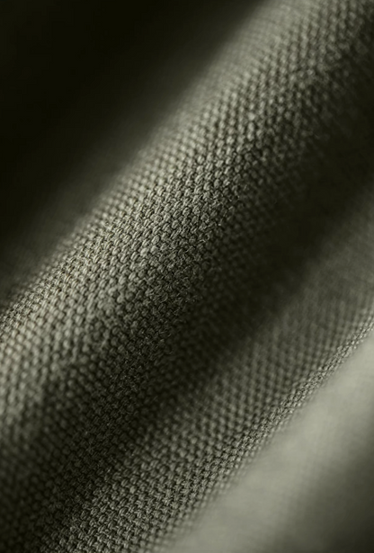 Close-up of olive green cotton fabric texture from M-65 utility jacket