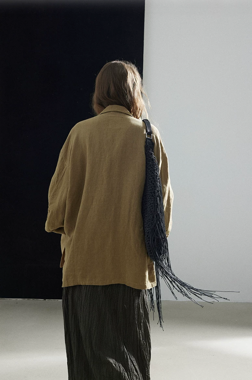 Back view of an olive linen shacket showing its oversized, straight cut
