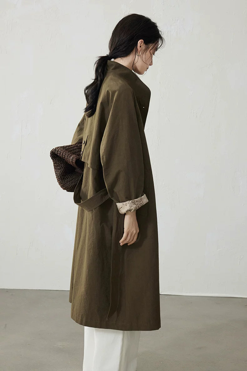 Back view of an Olive cotton trench coat showing the buttoned storm flap and tie belt