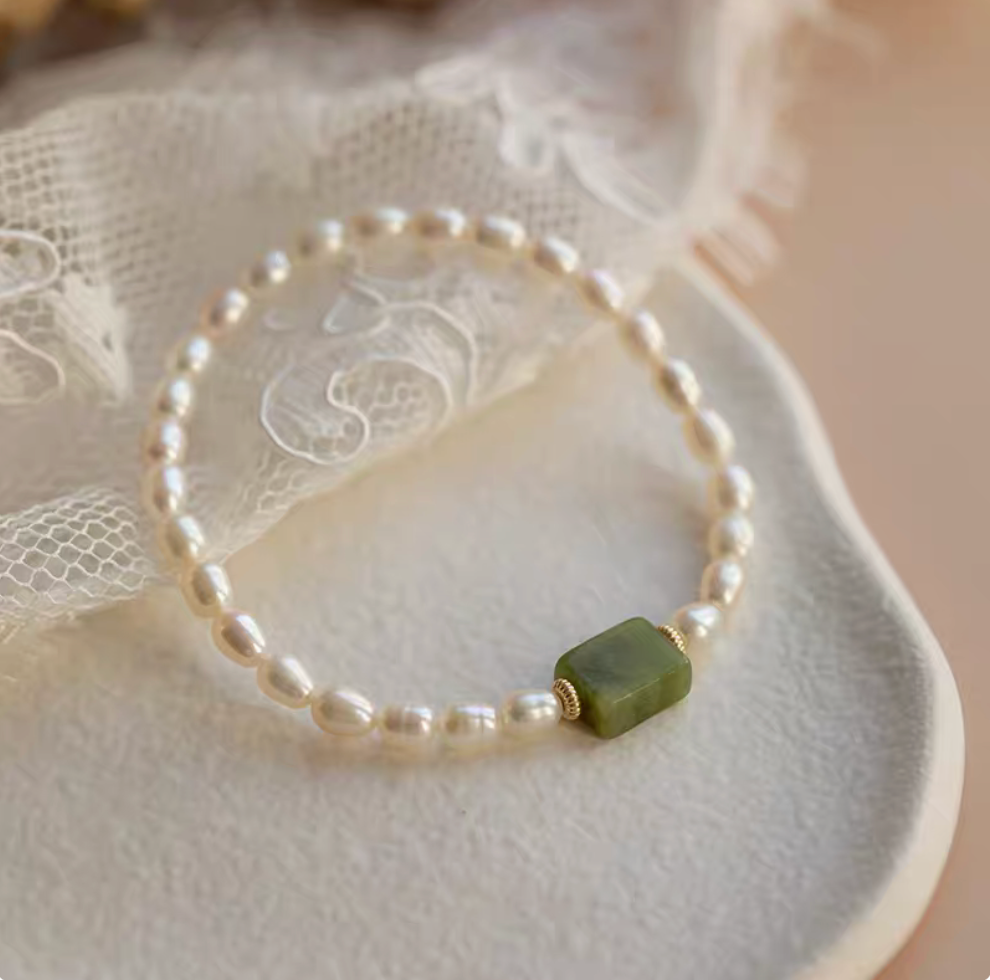 Top view of olivine pearl bracelet featuring square green jade centerpiece and evenly spaced natural pearls.