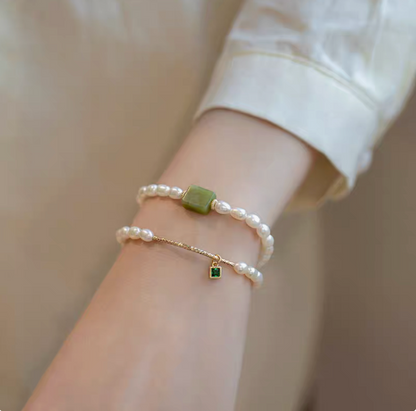 Lifestyle wrist photo featuring olivine pearl bracelet paired with square gemstone design bracelet in natural pearls.