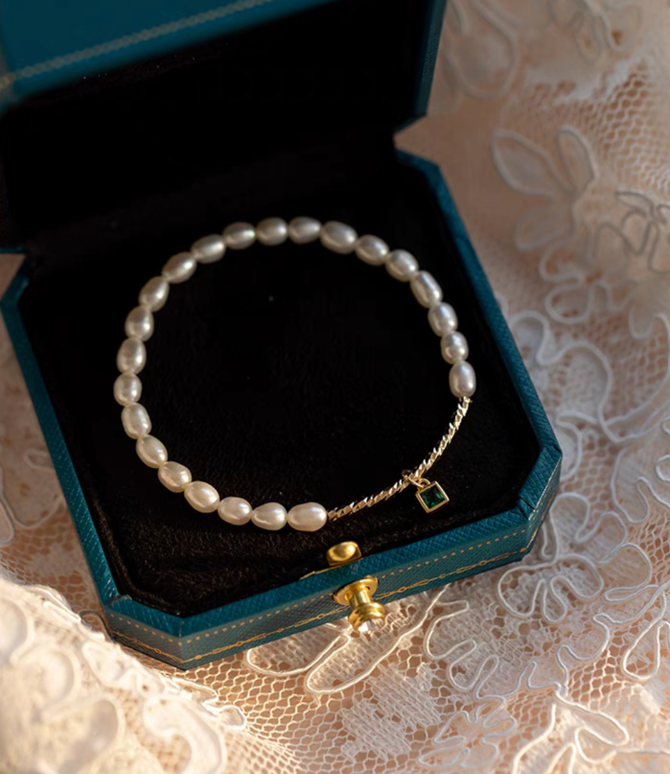 Square gemstone olivine pearl bracelet displayed inside a dark green jewelry box with natural pearl beads and gold detail.