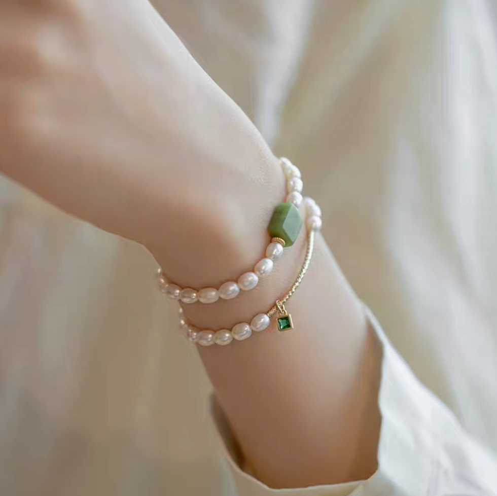 Lifestyle wrist shot showing square gemstone olivine pearl bracelet layered with olivine design bracelet in natural pearls.