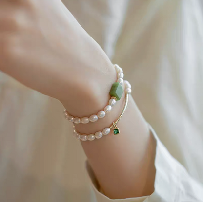 Lifestyle wrist shot showing square gemstone olivine pearl bracelet layered with olivine design bracelet in natural pearls.