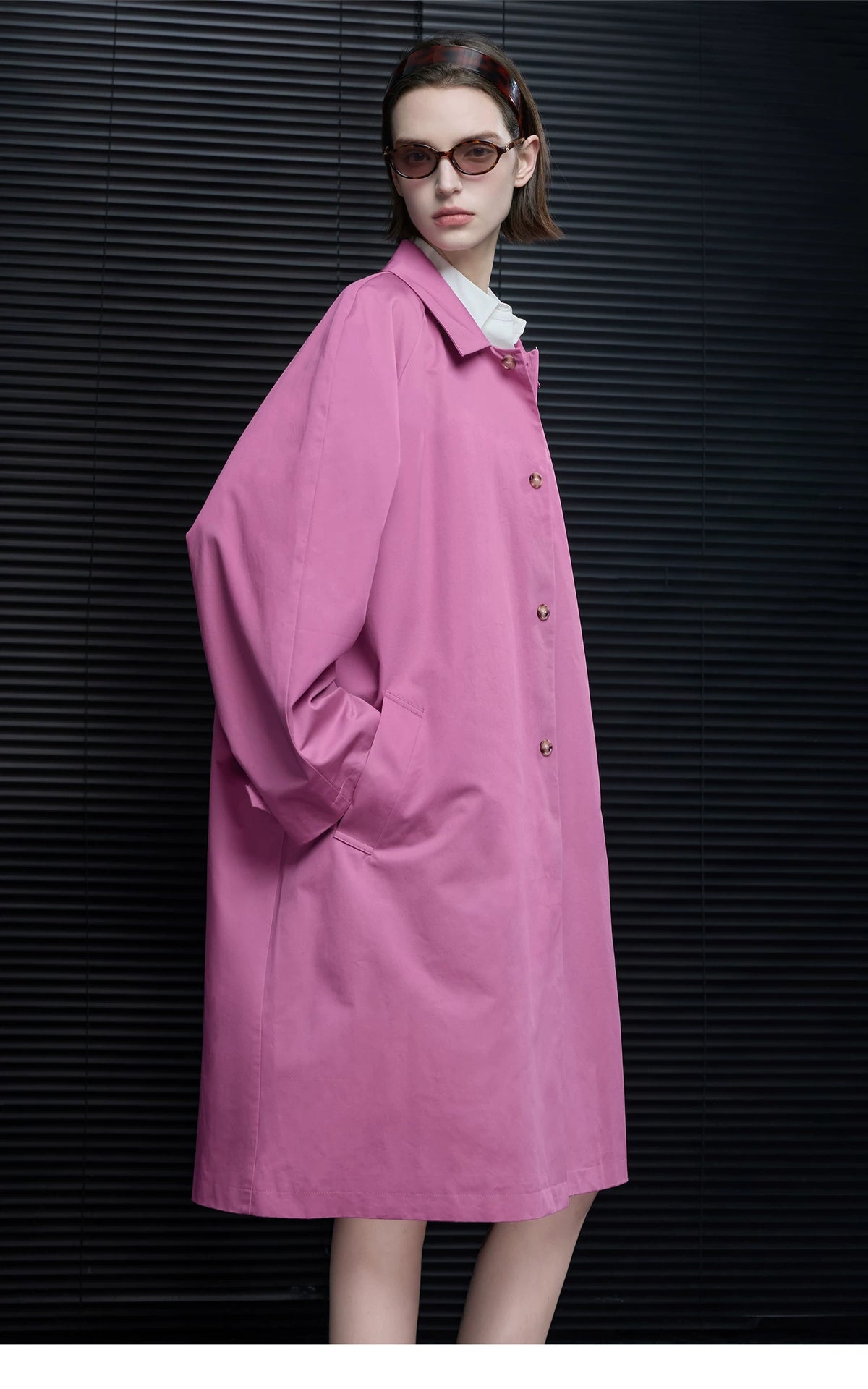 Side profile of an Orchid Pink oversized cotton swing coat with tortoiseshell-look buttons and welt pocket
