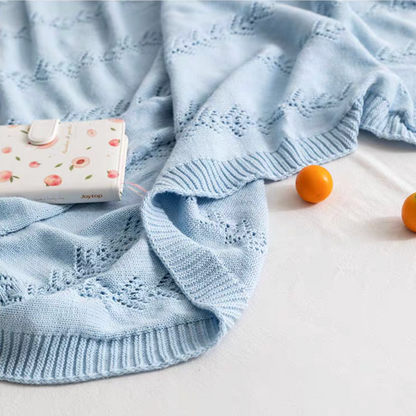 Close-up of Light Blue Oversize Knit Throw Blanket with decorative knit leaf pattern and ribbed edge