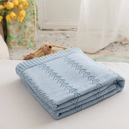 Folded Light Blue Oversize Knit Throw Blanket on a table highlighting soft lightweight cotton knit texture
