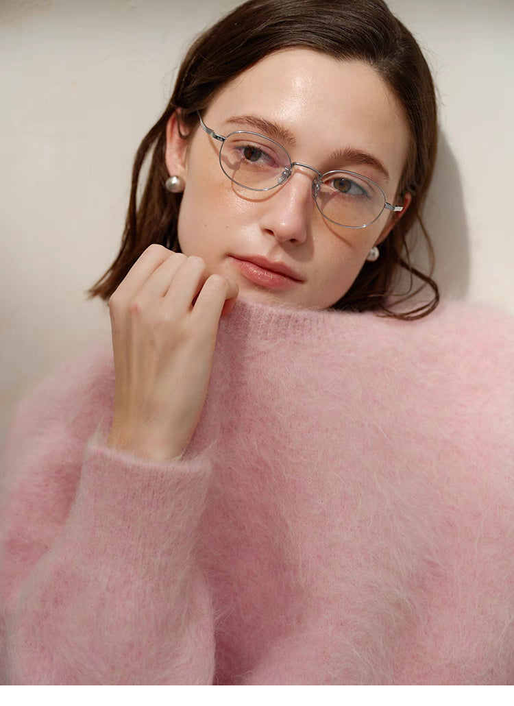 Pink alpaca crewneck sweater extreme close-up showing soft fuzzy fibers and neckline detail with model holding collar