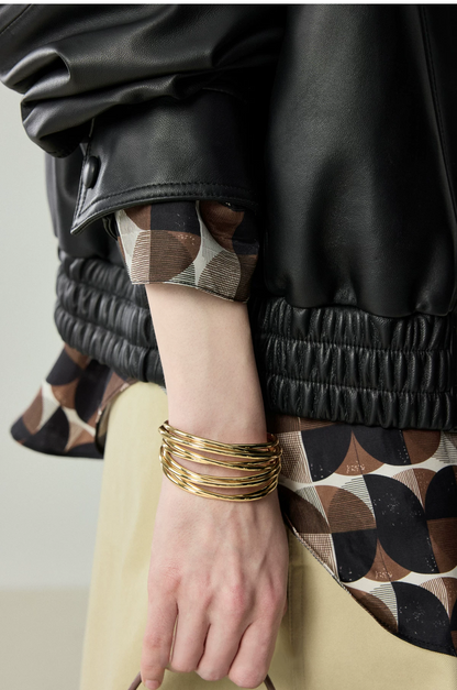 Close-up of black lambskin bomber showing snap cuff and shirred elastic leather hem