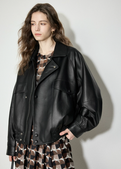 Side angle of black lambskin moto bomber showing raglan sleeves and gathered hem