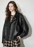 Side angle of black lambskin moto bomber showing raglan sleeves and gathered hem