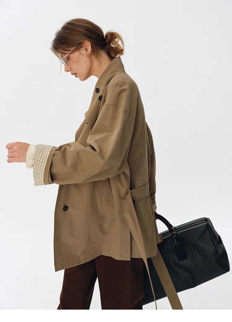 Side view of relaxed trench jacket with tie belt and rolled cuffs