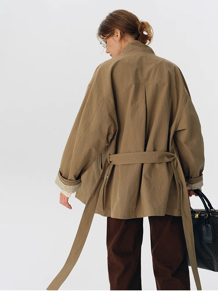 Back view showing relaxed drape and waist belt of trench jacket