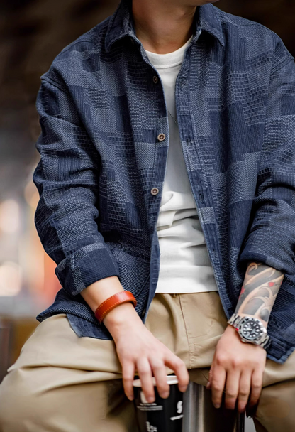 Denim Blue patchwork denim shirt styled in seated casual look highlighting layered outfit and textured Boro pattern
