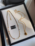 Classic pearl and tiger eye two-necklace set featuring multicolor beaded choker with freshwater pearls and gold tiger eye pendant necklace displayed on tray