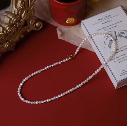 Petite baroque freshwater pearl necklace with 3 to 3.5mm pearls in natural color flat lay