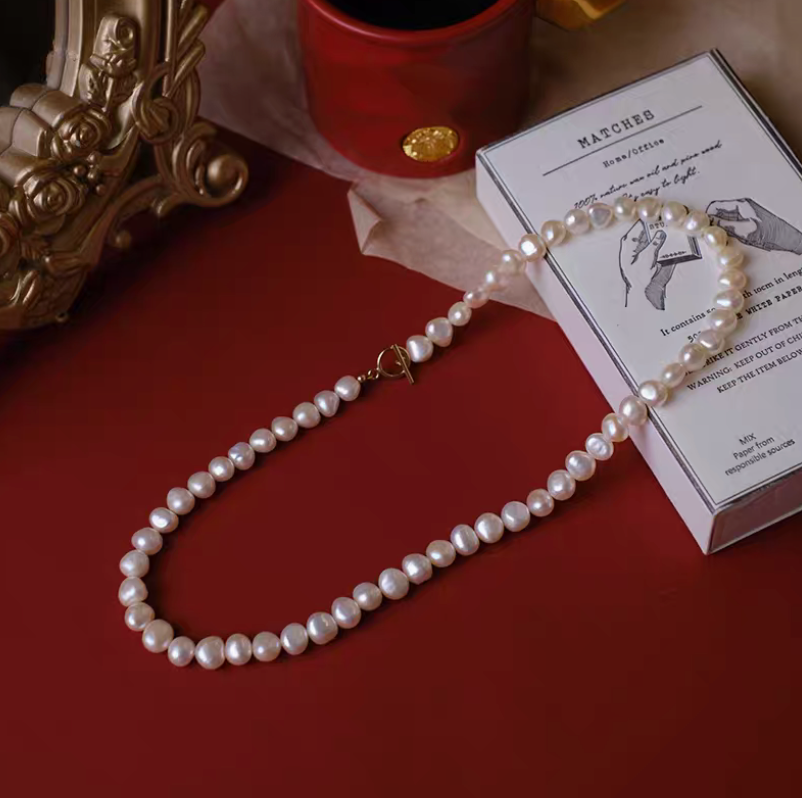 Petite baroque freshwater pearl necklace with 7 to 8mm pearls in natural color flat lay with clasp