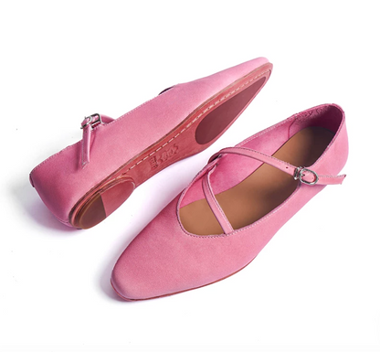 Pink ballet flats showing the leather outsole with rubber grip patches and asymmetric topline