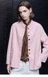 Pink linen band-collar jacket worn open, showing the mismatched button front and patch pockets