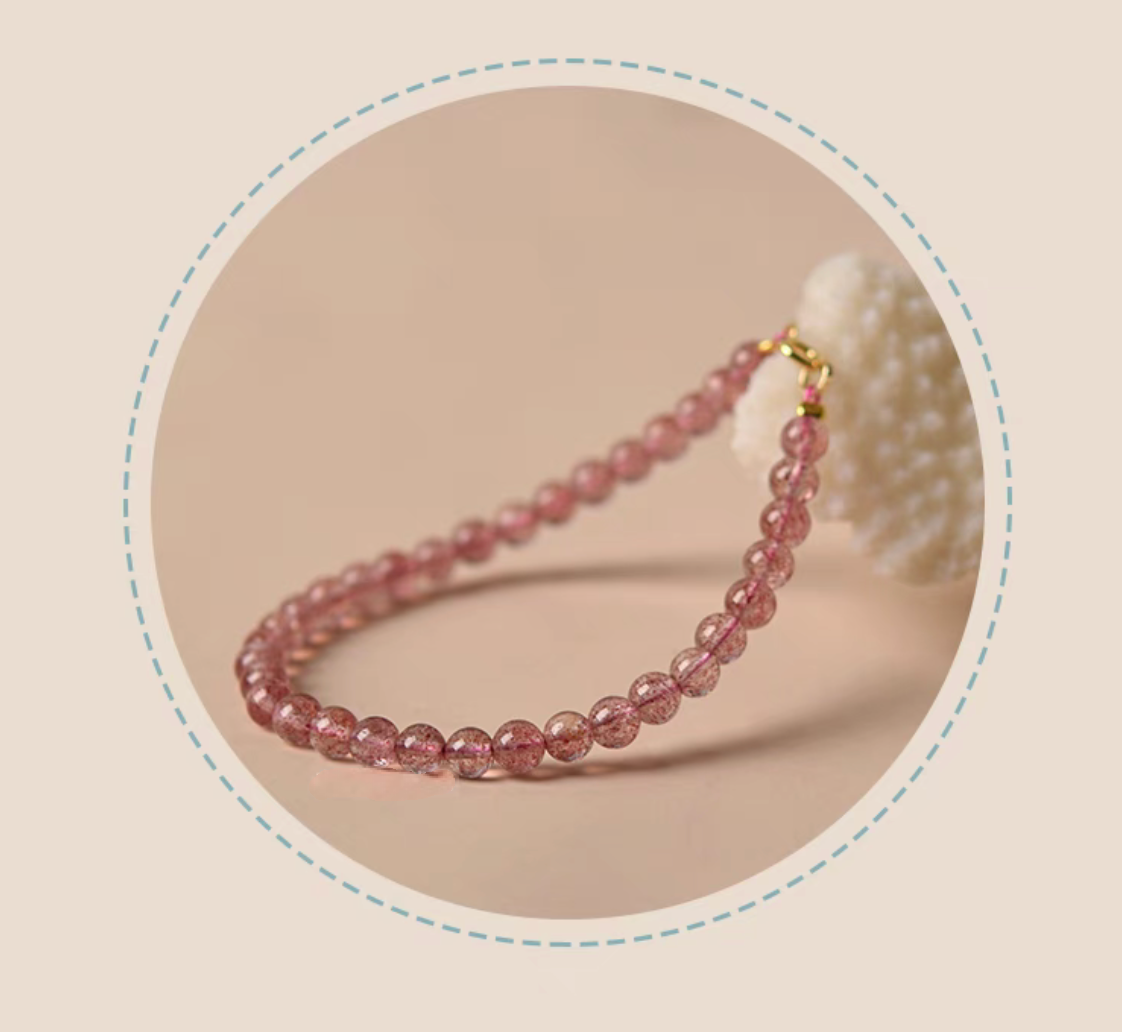 Angled view of pink strawberry quartz bead bracelet in soft lighting with elegant lifestyle styling