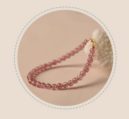 Angled view of pink strawberry quartz bead bracelet in soft lighting with elegant lifestyle styling