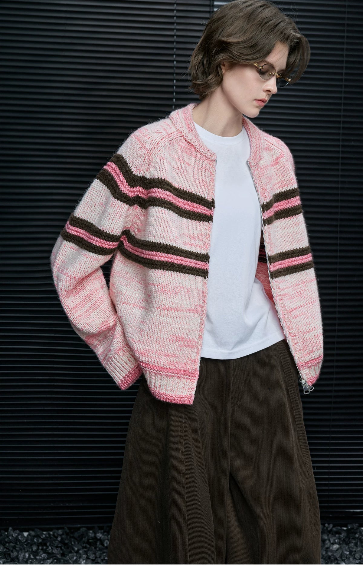 Woman wearing Pink Stripe chunky knit zip cardigan open over a white tee with brown corduroy pants