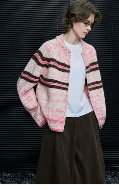 Woman wearing Pink Stripe chunky knit zip cardigan open over a white tee with brown corduroy pants
