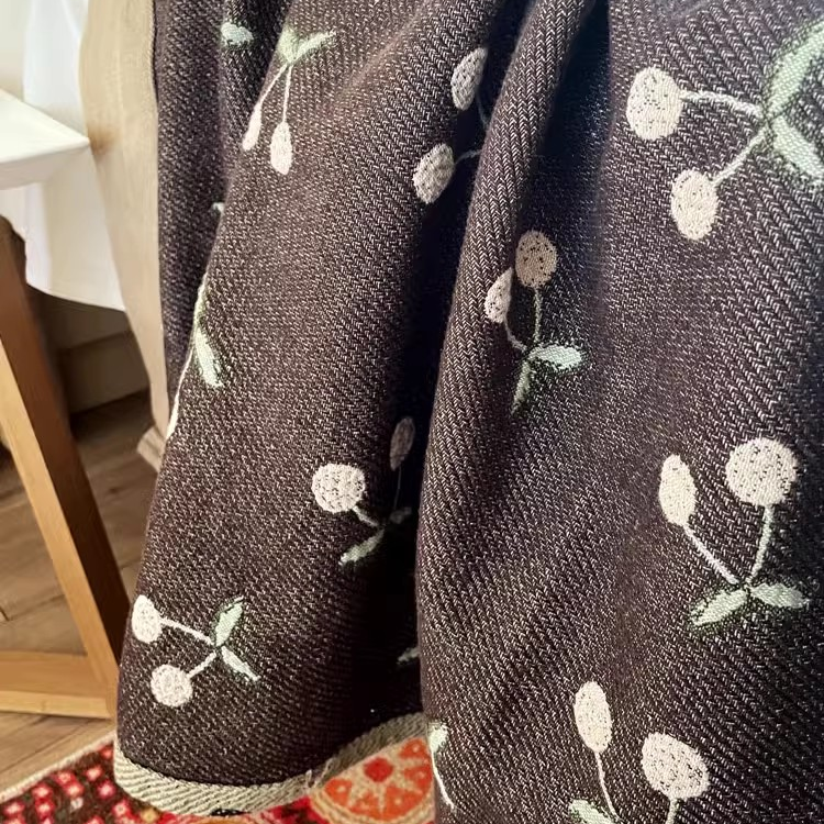 Detailed view of Playful Pals Cotton Gauze Quilted Blanket Black Cherry highlighting cotton gauze weave and cherry motif