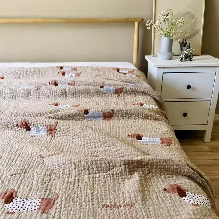 Playful Pals Cotton Gauze Quilted Blanket Puppy styled on a bedroom bed featuring adorable dachshund dog pattern