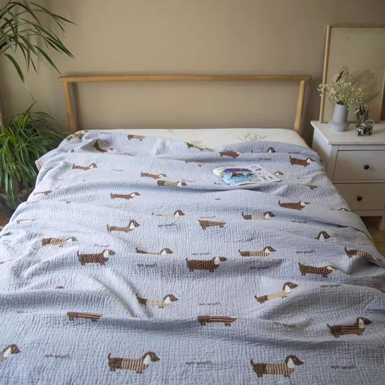 Playful Pals Cotton Gauze Quilted Blanket Puppy styled on a bed in a bright bedroom with dachshund dog print bedding