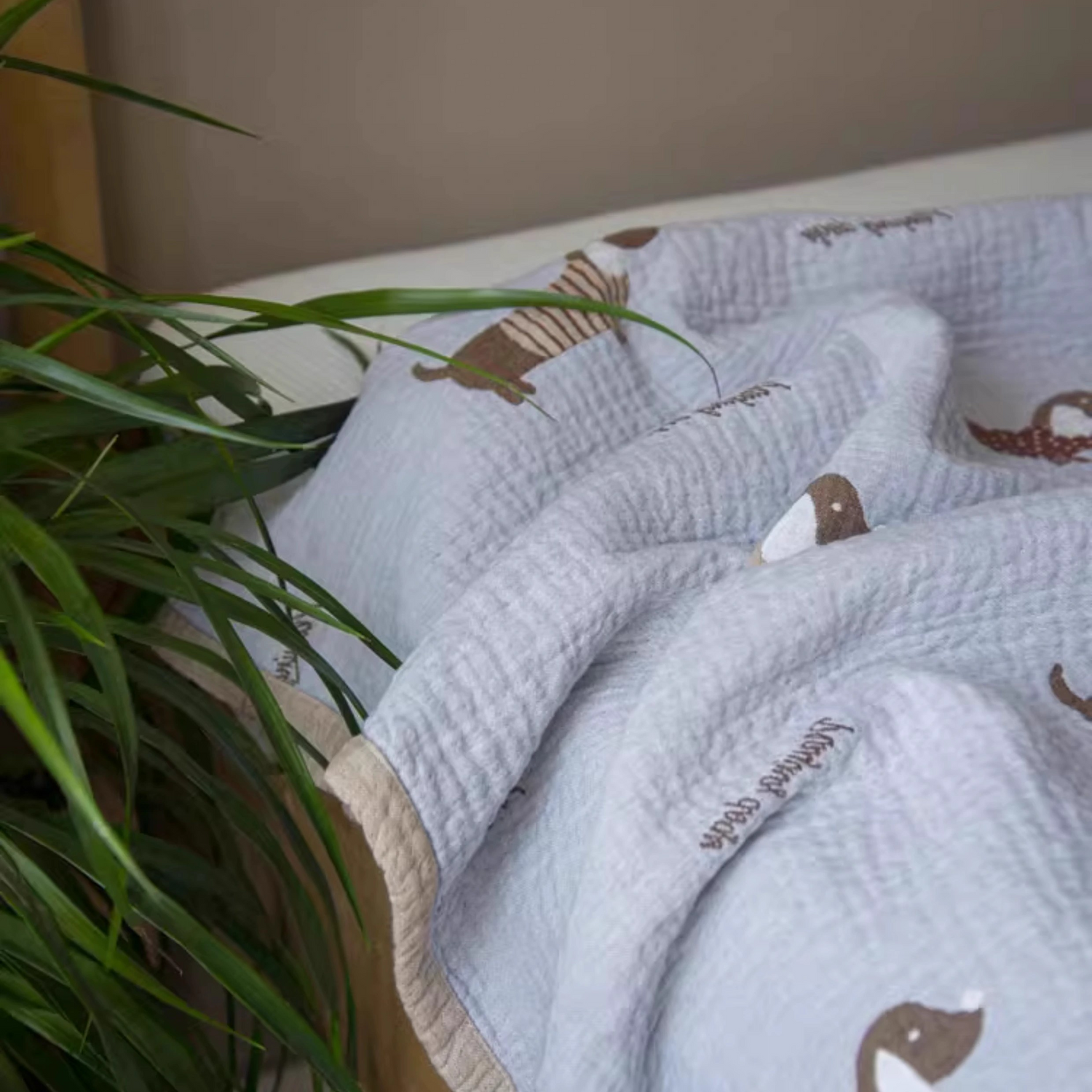 Playful Pals Cotton Gauze Quilted Blanket Puppy spread across bed with playful dachshund pattern design